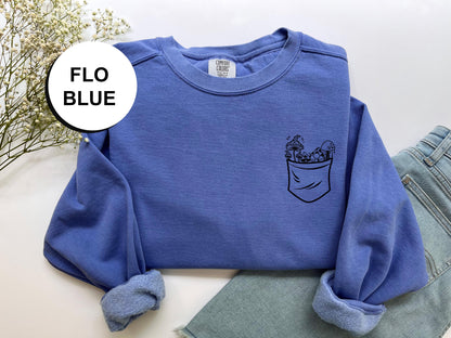 a blue sweatshirt with a flower in a pocket