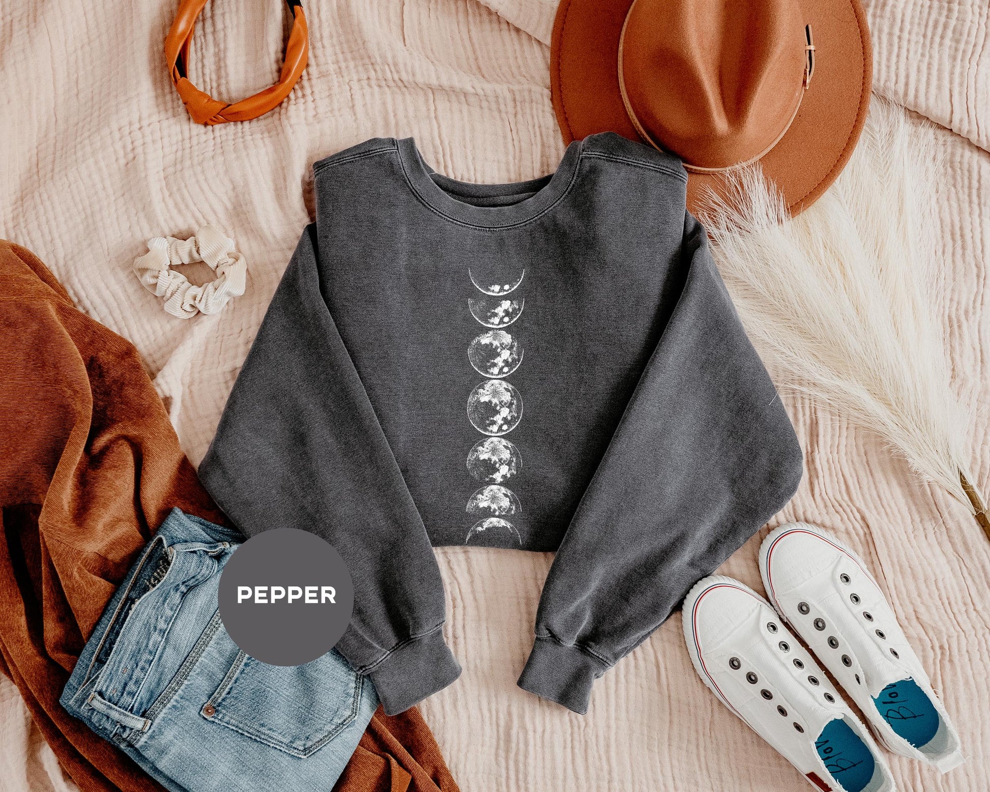 a crop top, jeans, hat, and slip on a bed
