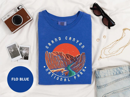 a blue t - shirt with a picture of a mountain and a river on it