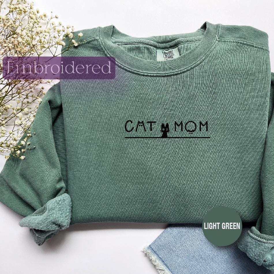a green shirt with the word cat mom on it
