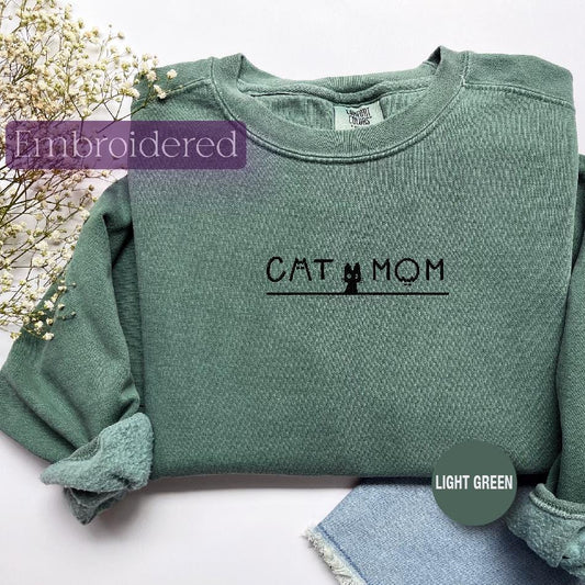 a green shirt with the word cat mom on it