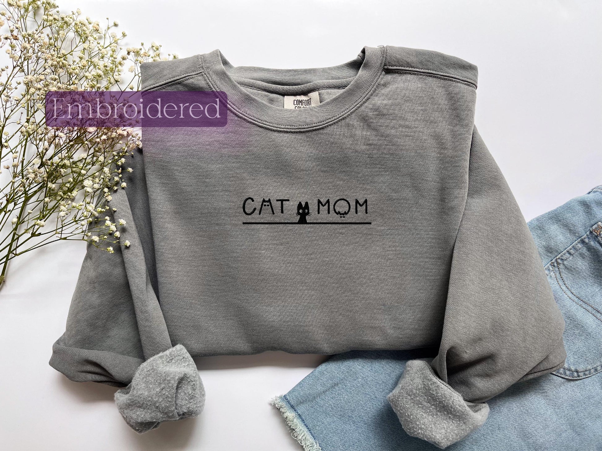 a gray sweatshirt with the word cat mom printed on it