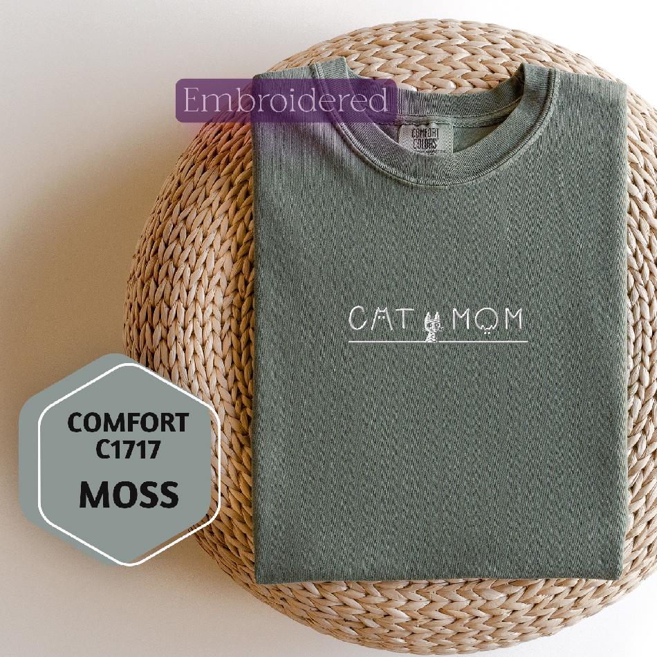 a cat mom shirt sitting on top of a wicker basket