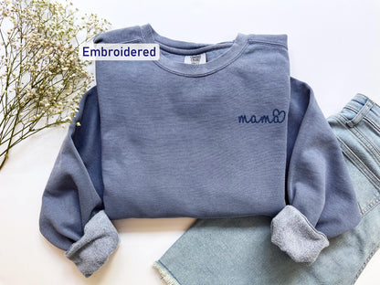 a blue sweatshirt with a name on it next to a pair of jeans