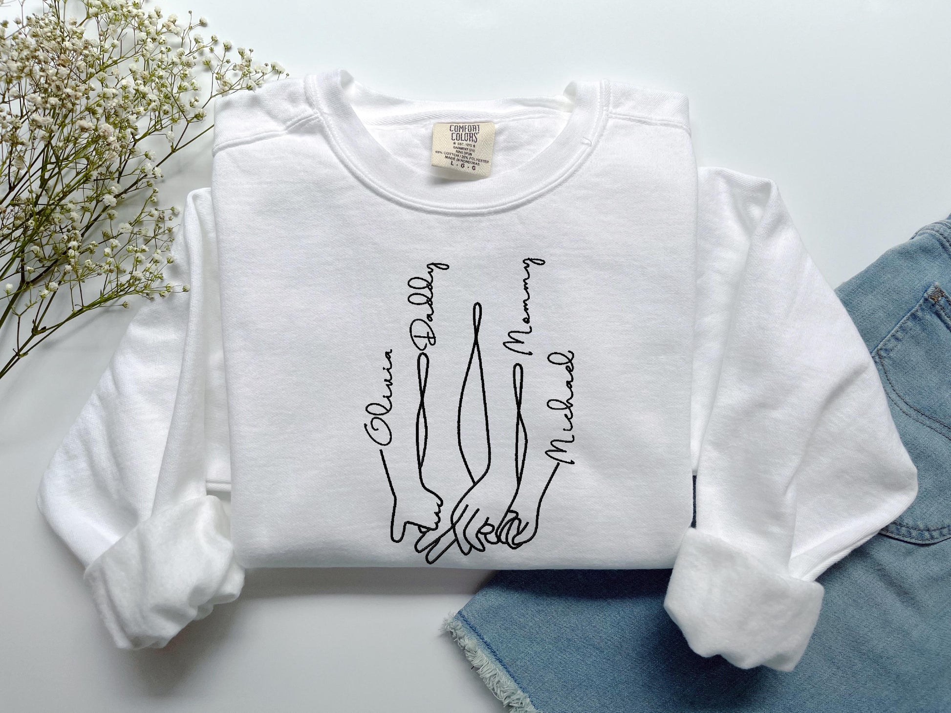 a white shirt with a drawing of two hands on it