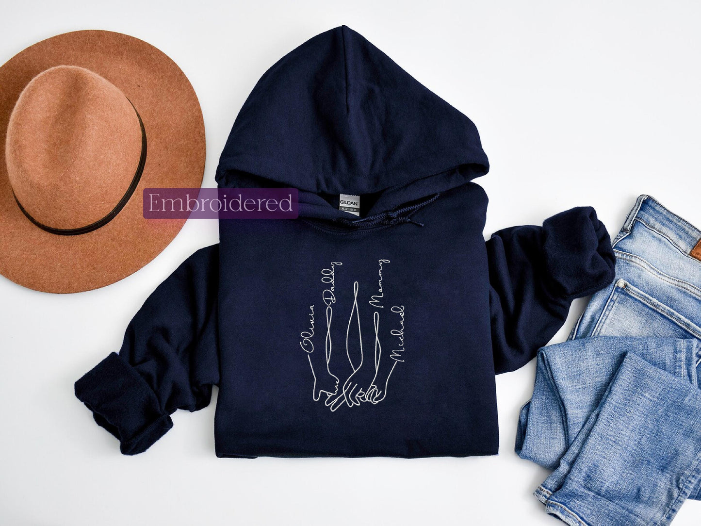 a hat, jeans, and a hoodie on a white surface