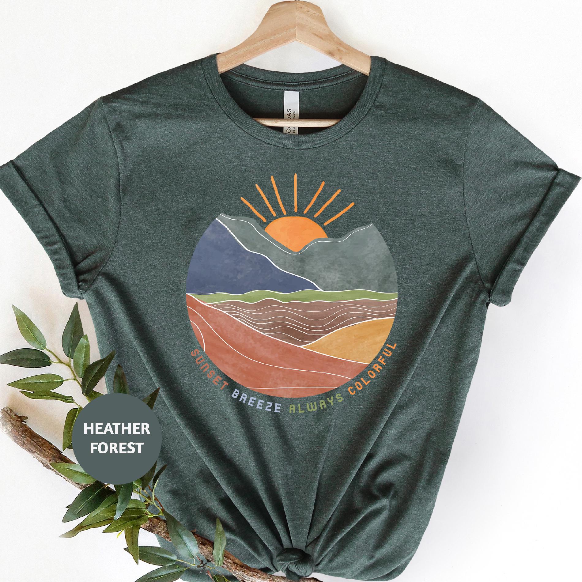 a green t - shirt with a picture of a mountain range