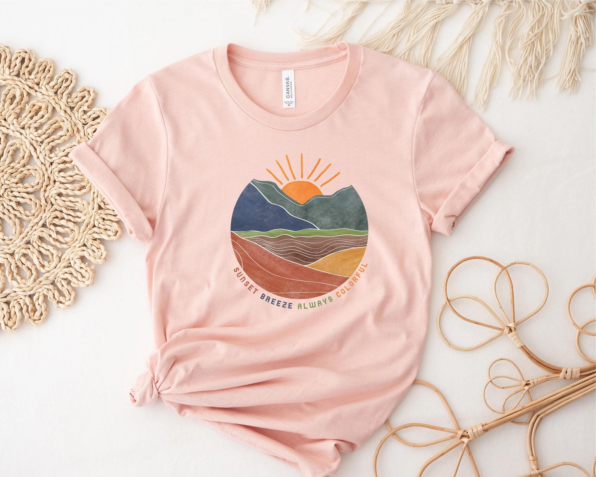 a pink t - shirt with a mountain scene on it