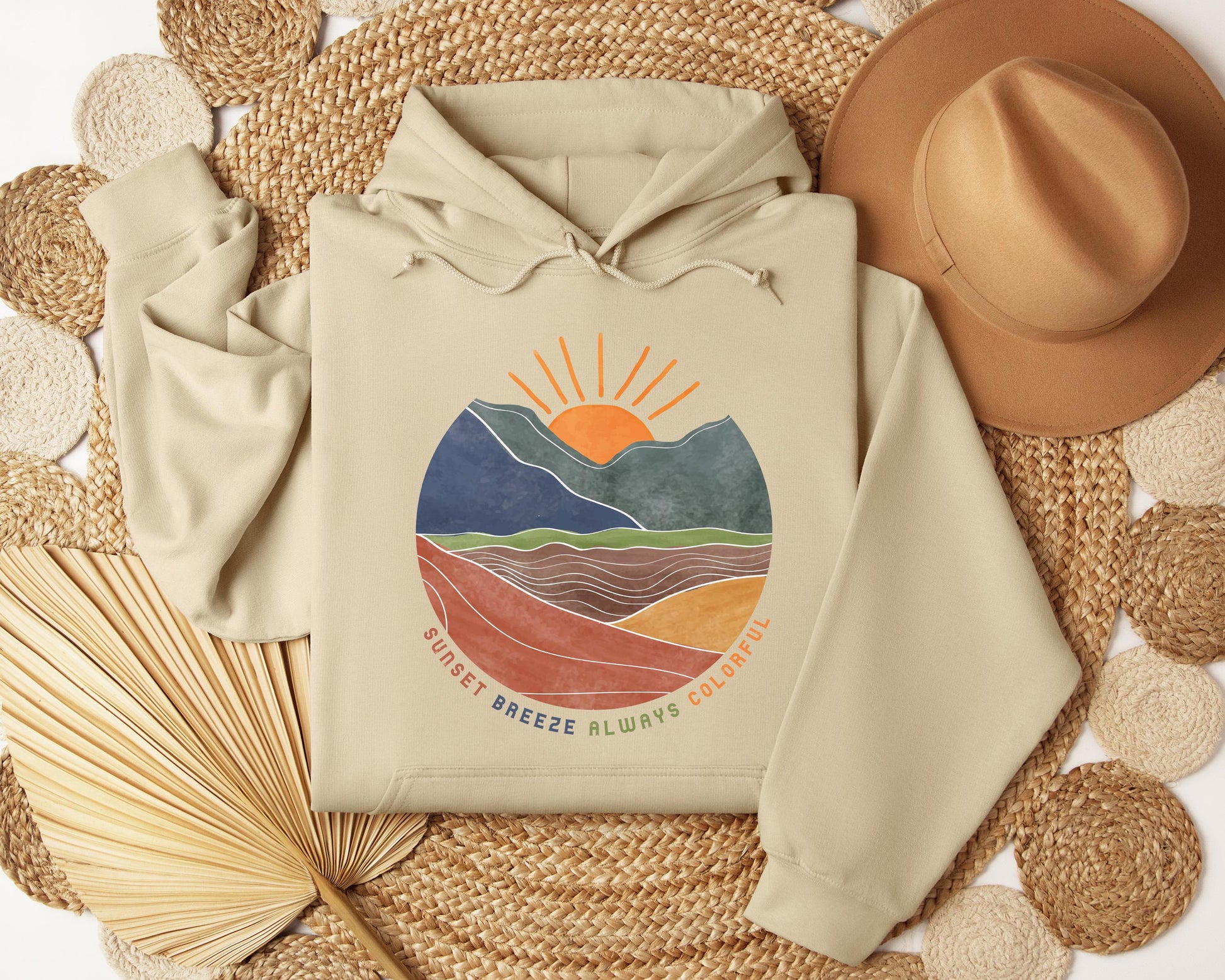 a hoodie sitting on top of a table next to a straw hat