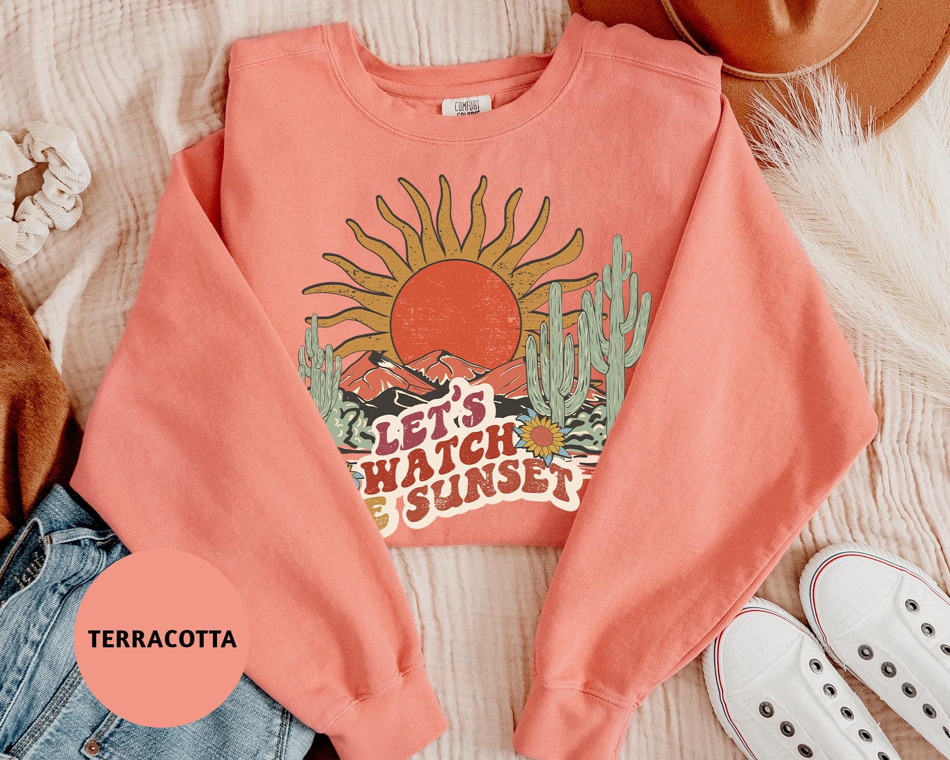 a pink sweatshirt with a picture of a sun on it