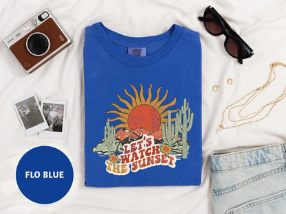 a blue t - shirt with a picture of a sunset on it