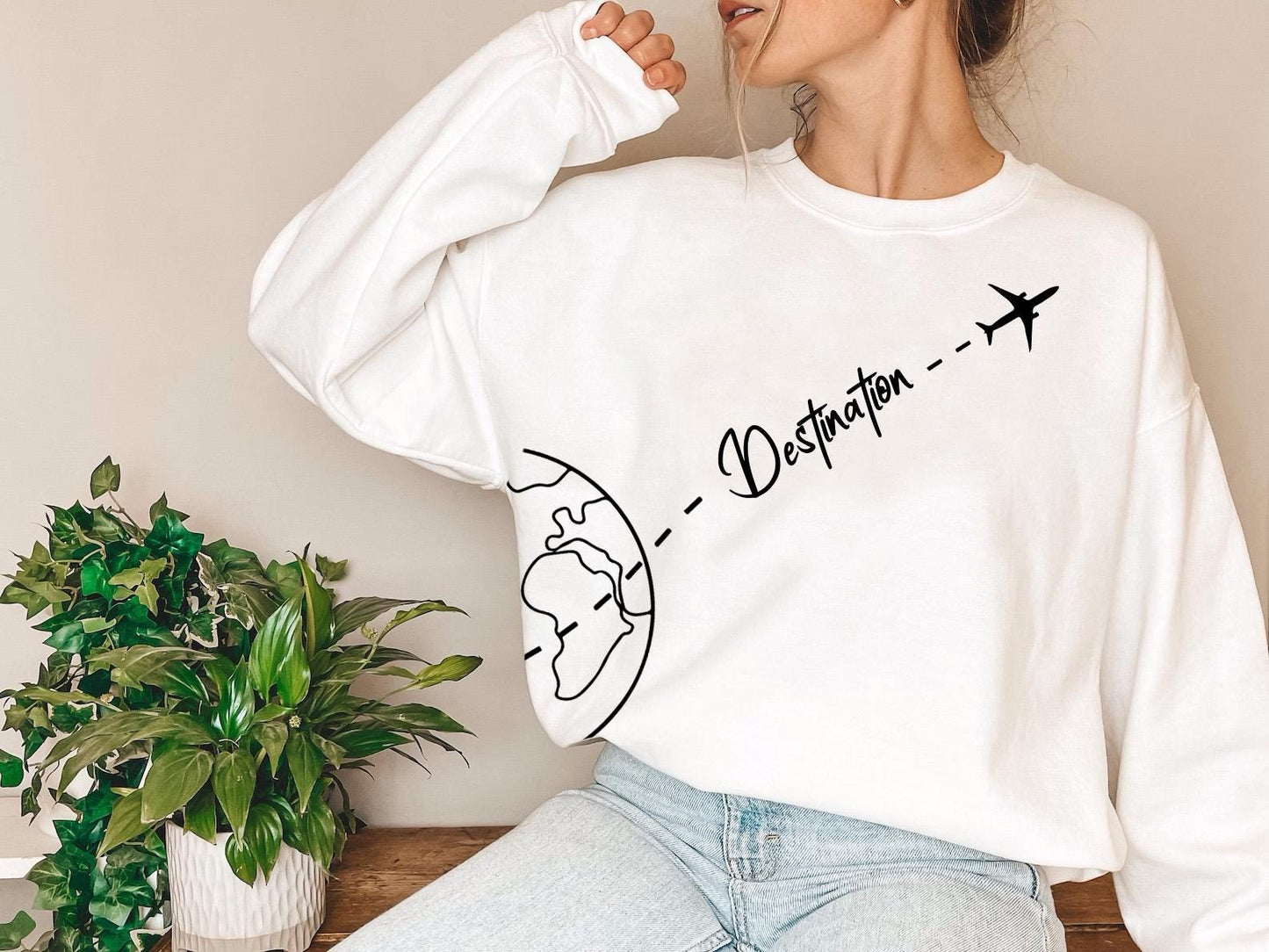 a woman sitting on a table wearing a white sweatshirt