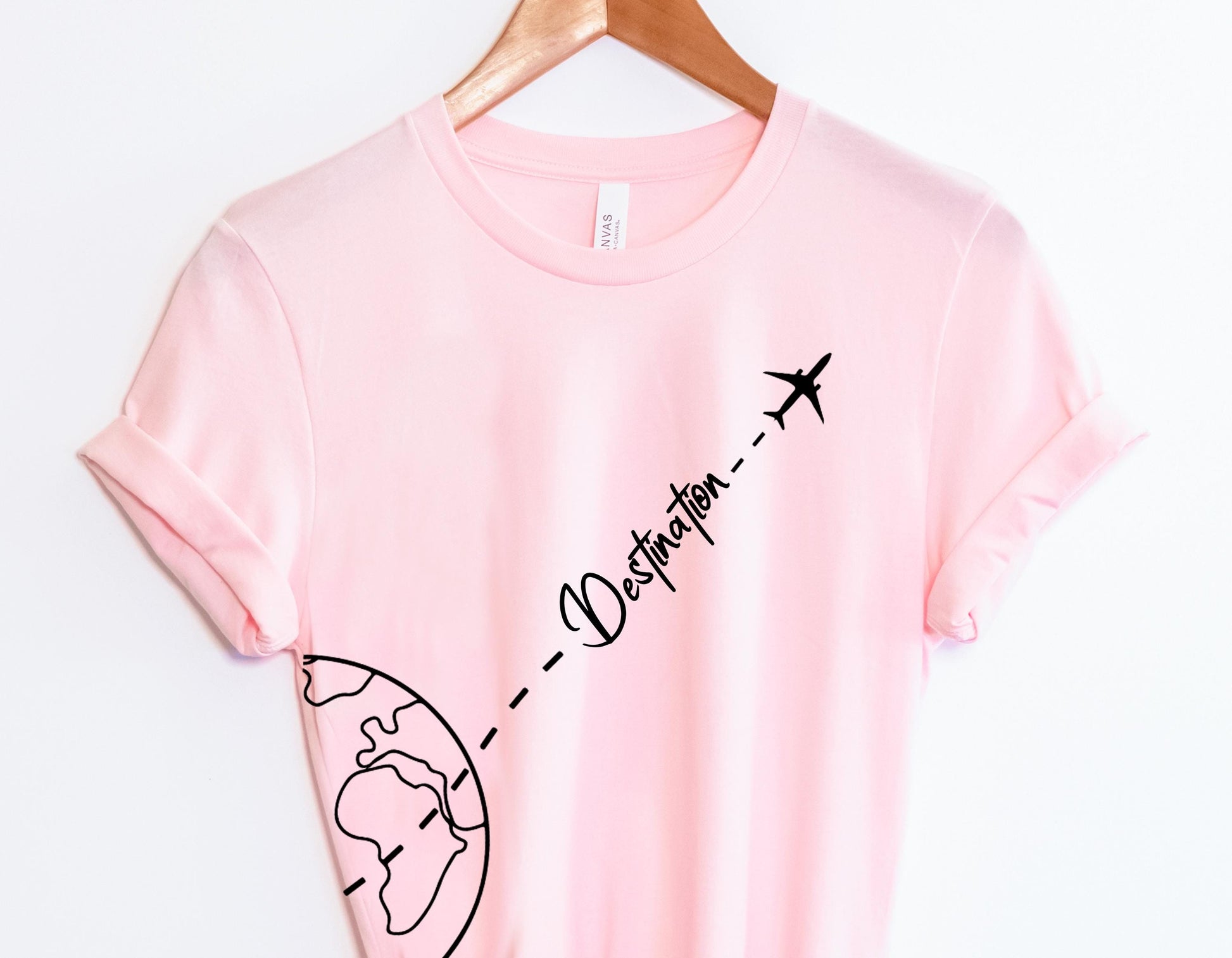 a pink t - shirt with a picture of a plane flying over the earth