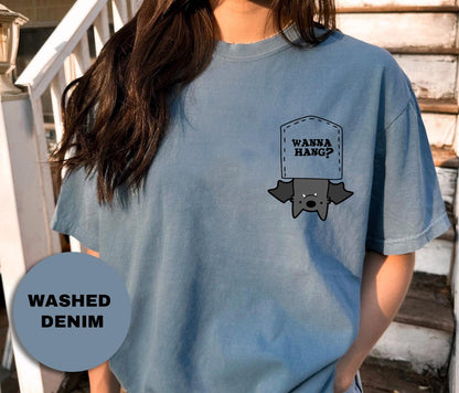 a woman wearing a blue tshirt with the words wanna hang? on it