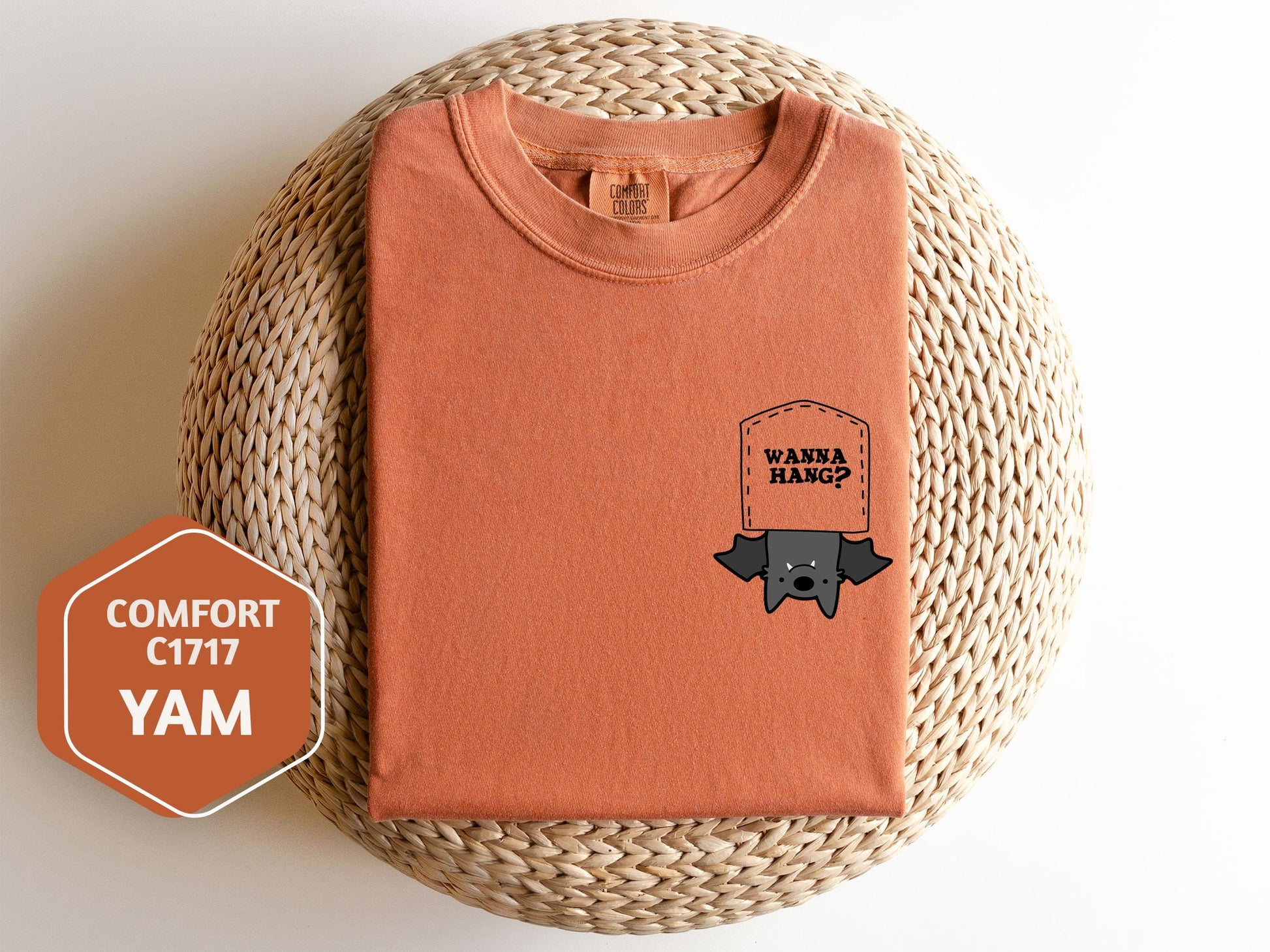 a t - shirt with a sticker on it next to a wicker basket