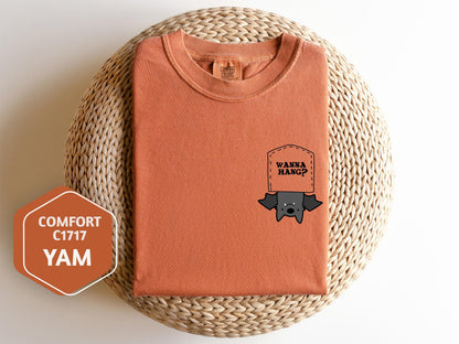 a t - shirt with a sticker on it next to a wicker basket