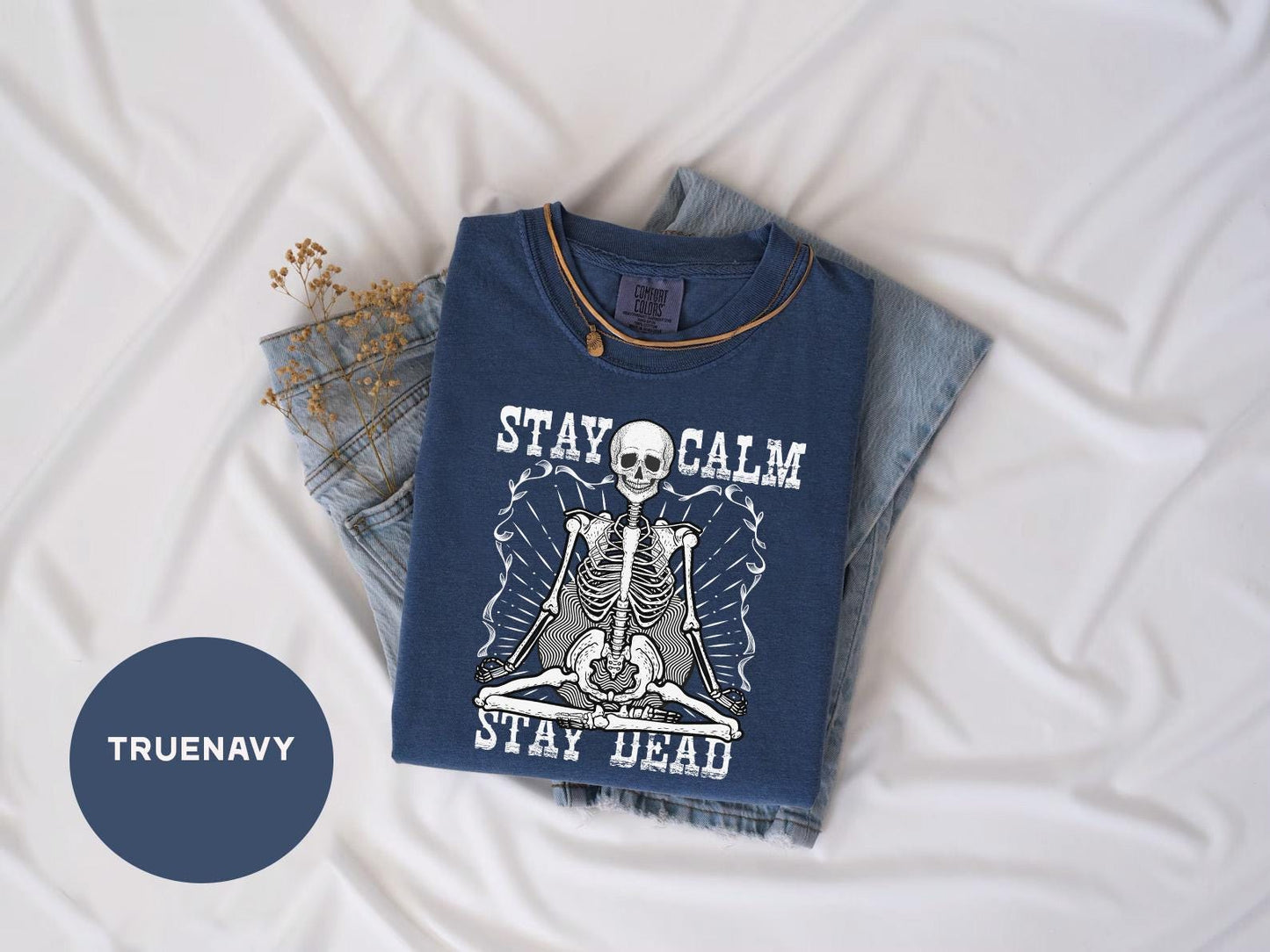 a t - shirt with a skeleton on it sitting next to a pair of jeans