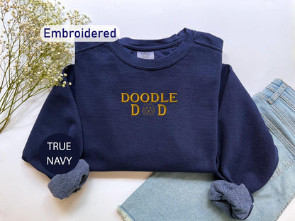a t - shirt that says doodle do is next to a pair of jeans