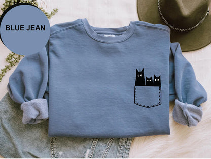 a blue jean shirt with black cats in a pocket