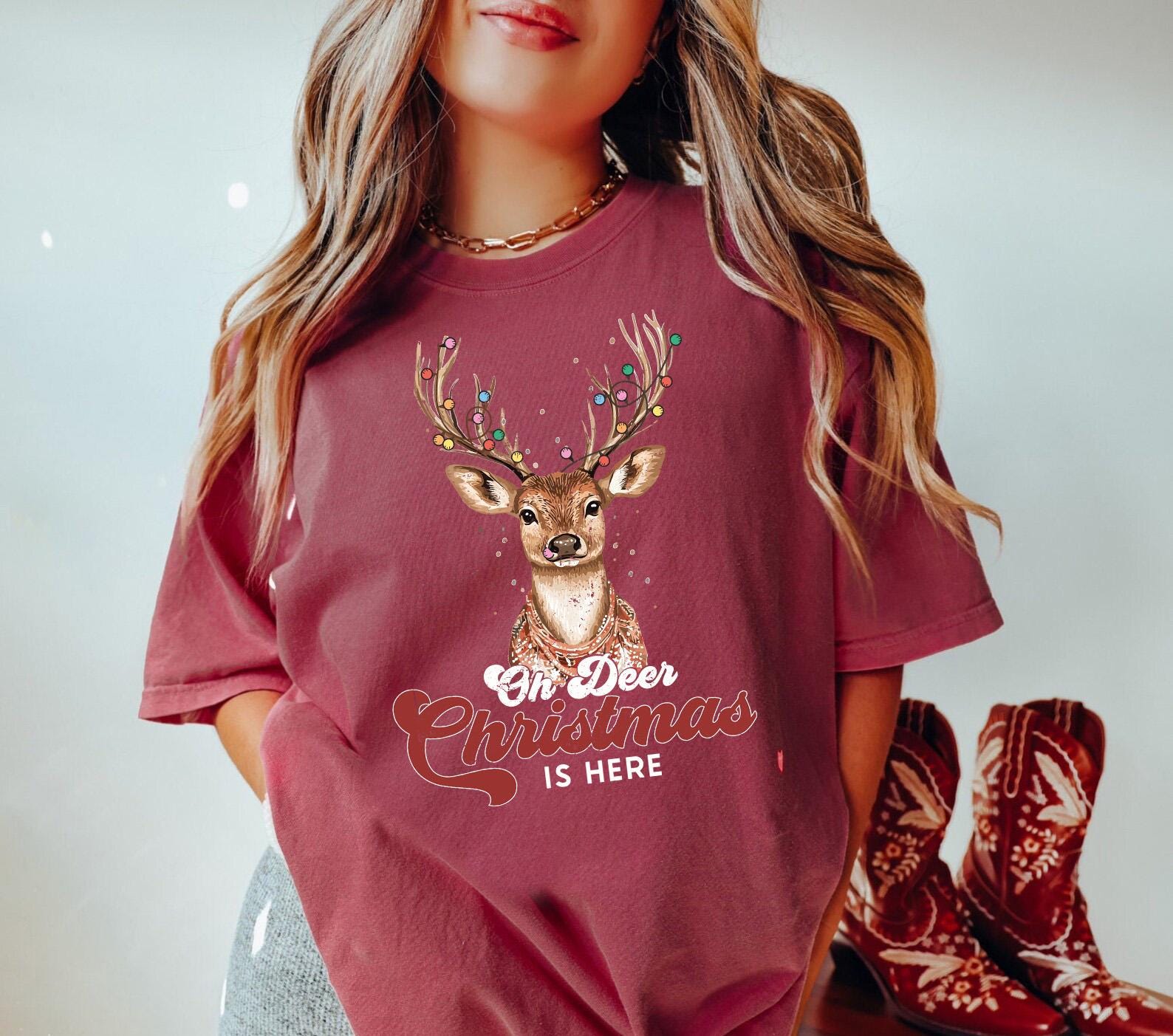 a woman wearing a red christmas shirt with a deer on it