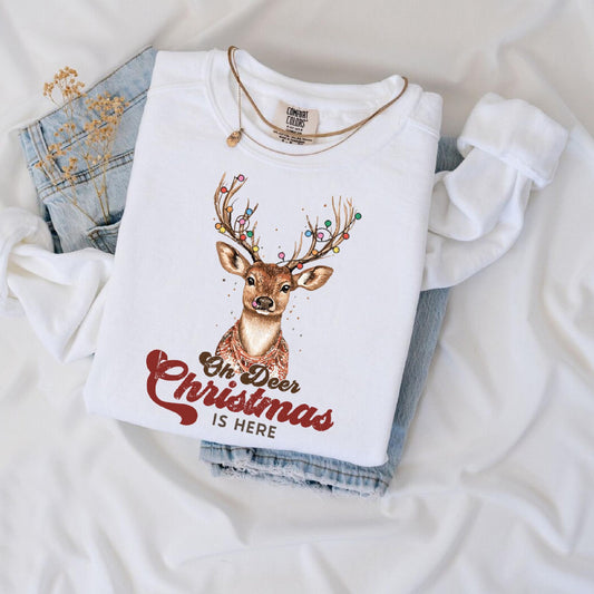a white t - shirt with a deer on it next to a pair of jeans