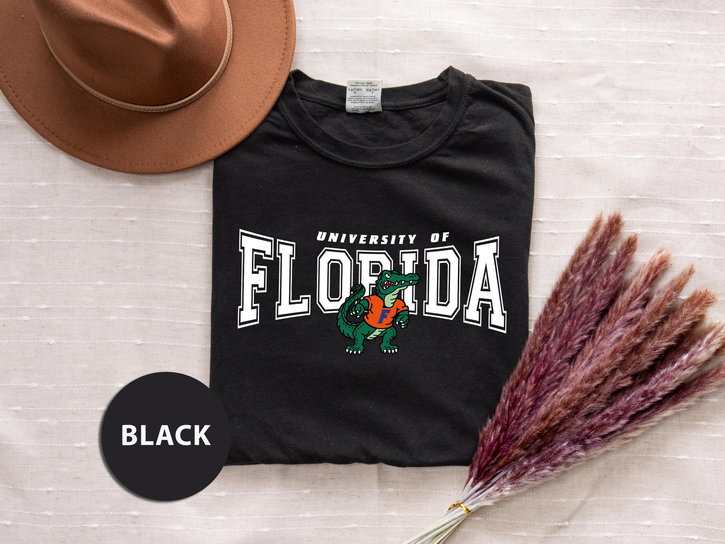a t - shirt with the university of florida on it next to a hat and