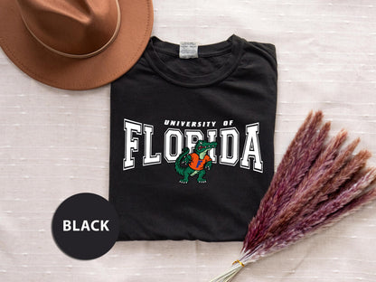 a t - shirt with the university of florida on it next to a hat and