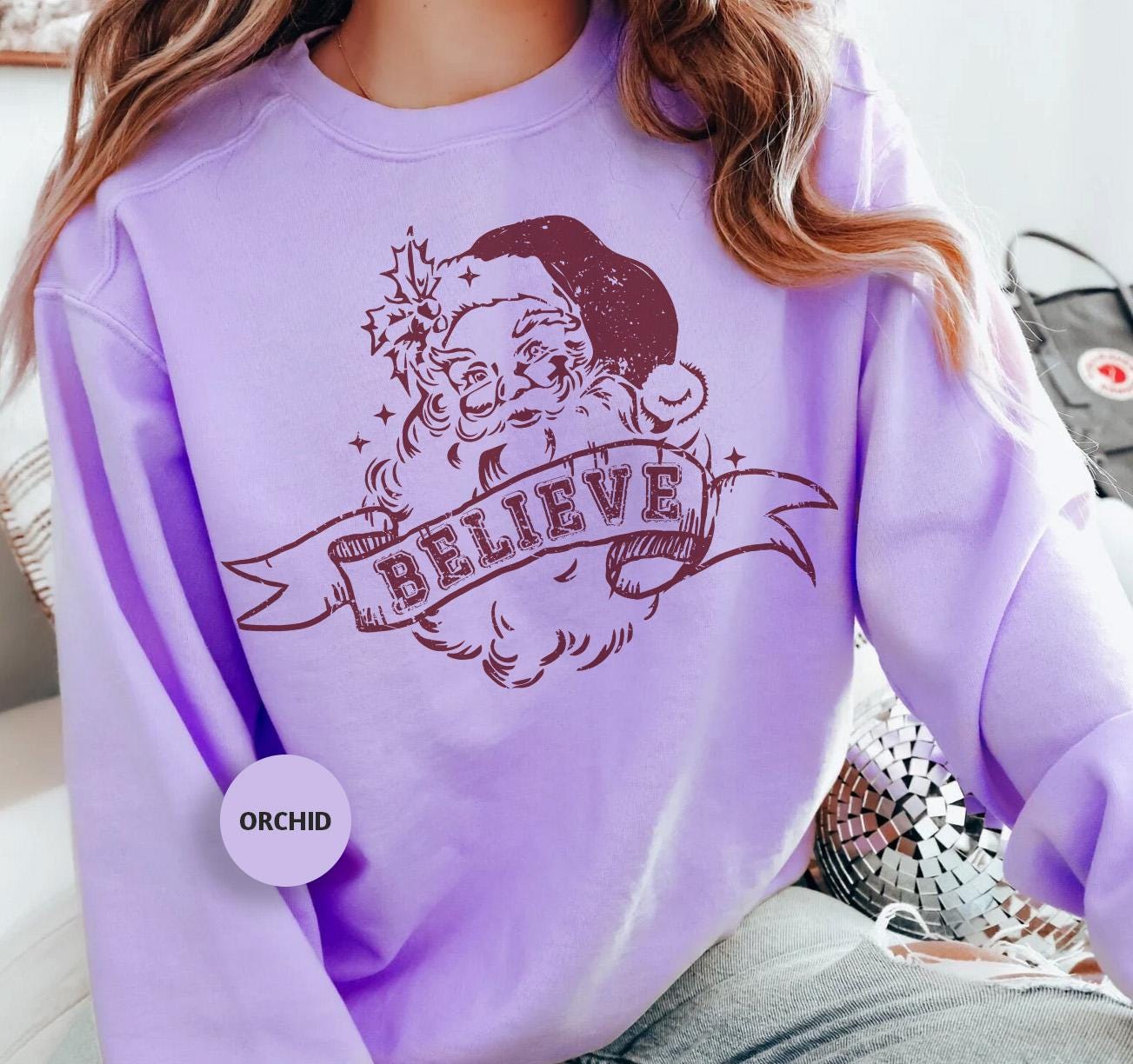 a woman wearing a purple sweatshirt with a santa clause on it