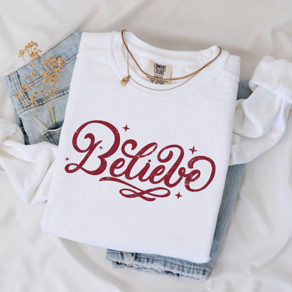 a white shirt that says believe on it