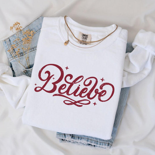a white shirt that says believe on it