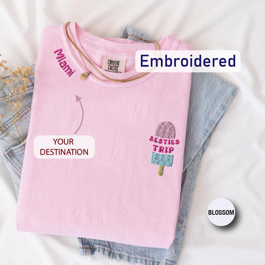 a pink t - shirt with embroidered words on it