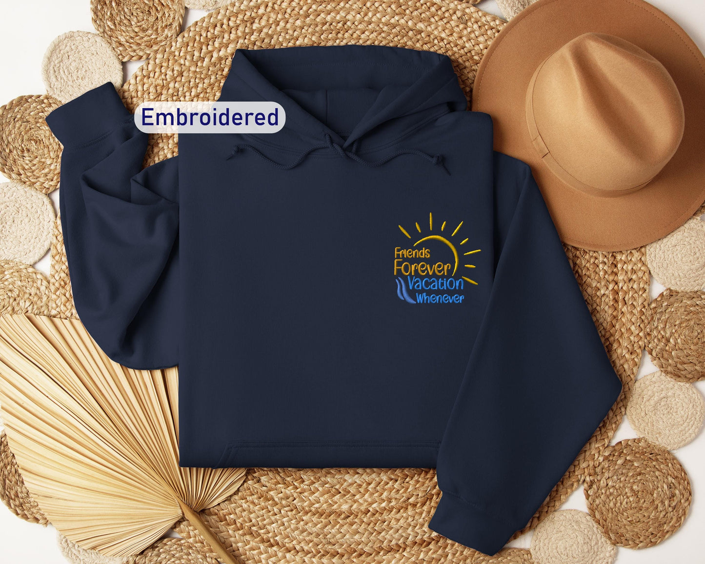 a blue hoodie with a sun on it and a straw hat next to it