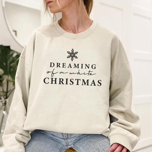 a woman wearing a sweatshirt that says dreaming of a white christmas
