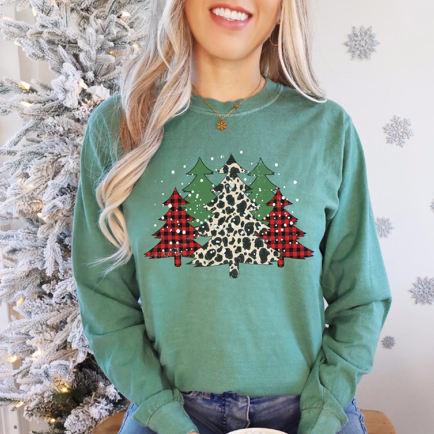 a woman wearing a green sweater with a leopard print christmas tree on it