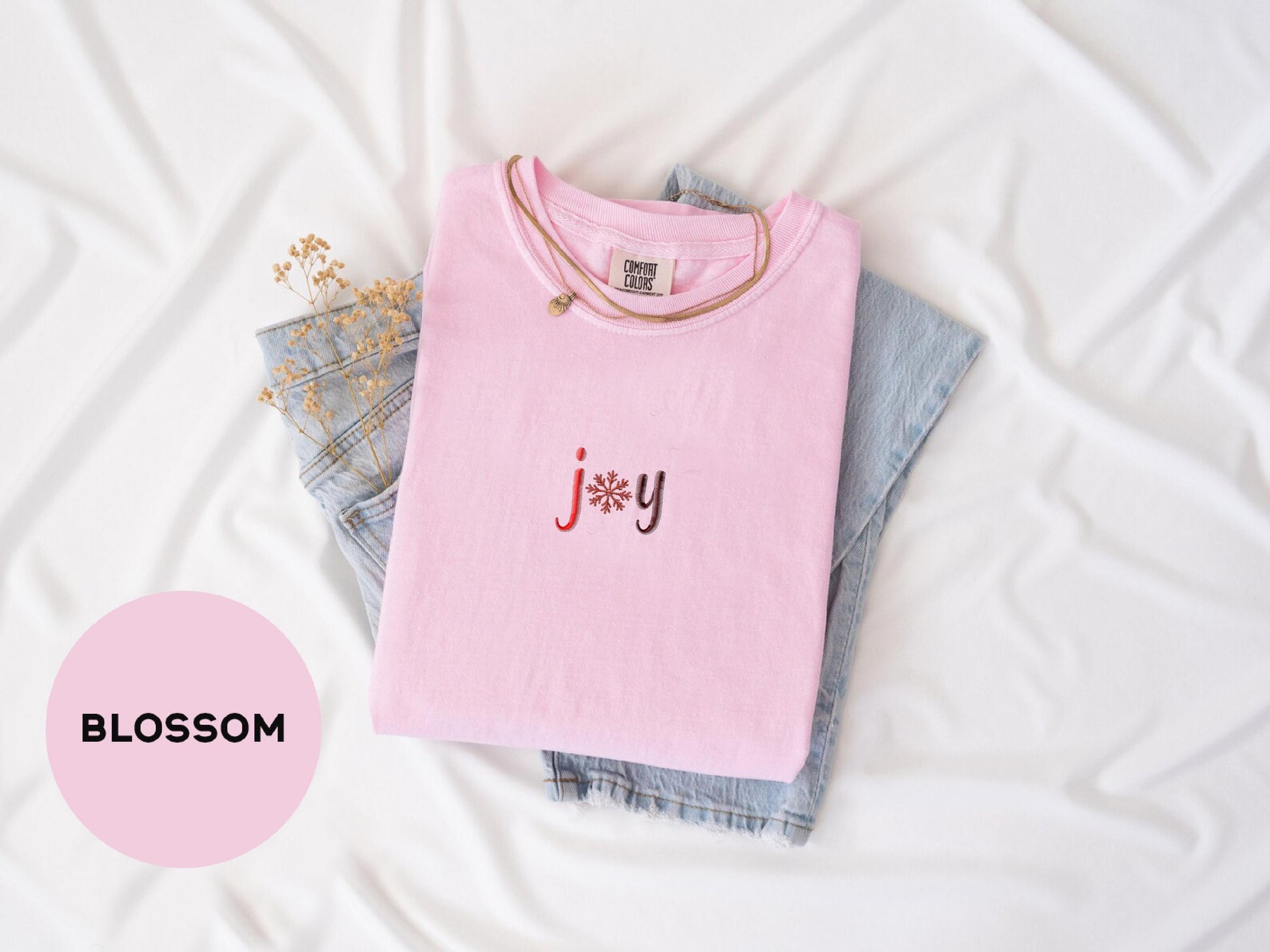 a pink t - shirt with the word jy on it next to a pair
