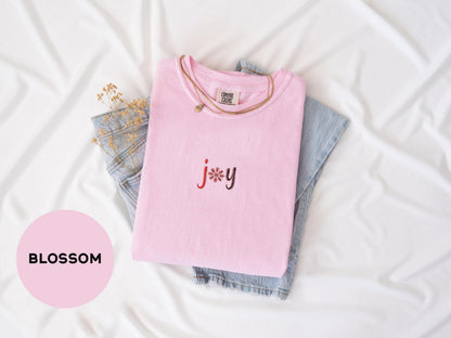 a pink t - shirt with the word jy on it next to a pair