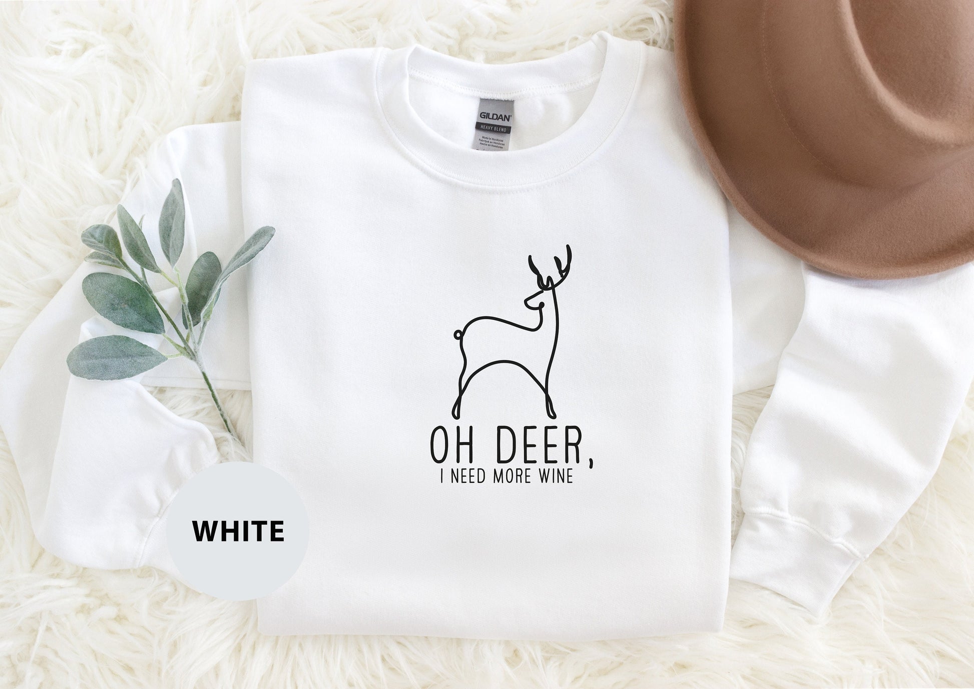 a white shirt with a deer on it and a brown hat