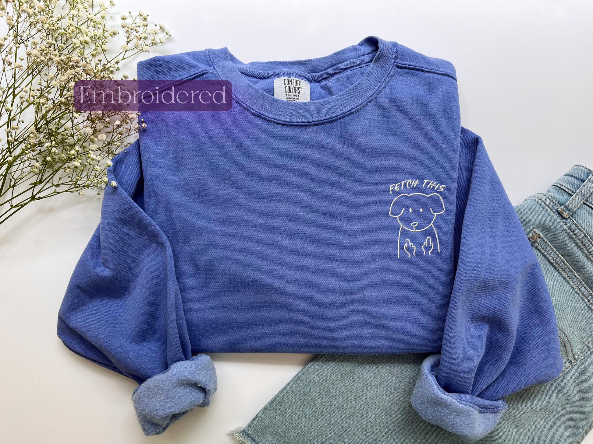 a blue sweater with a dog embroidered on it