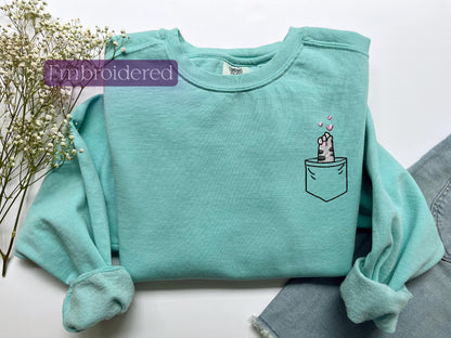 a t - shirt with a cat in a pocket on it