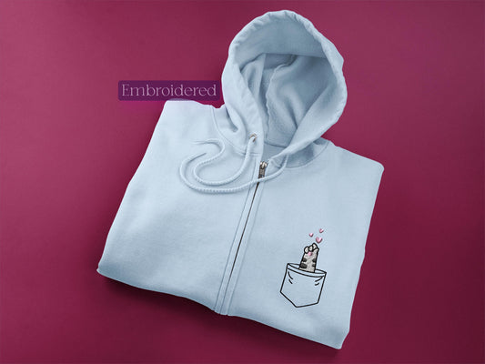 a white zip up hoodie with a picture of a dog in a pocket