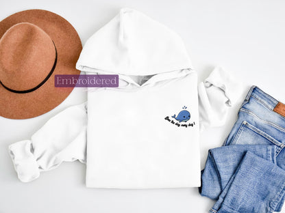 a hat, jeans, and a sweatshirt are laid out on a white surface