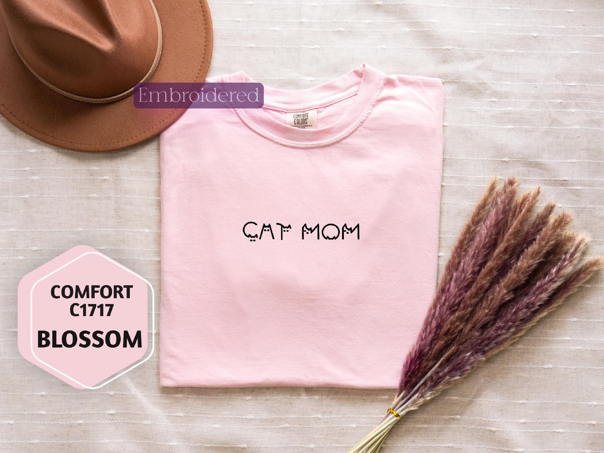 a pink shirt with a cat mom written on it