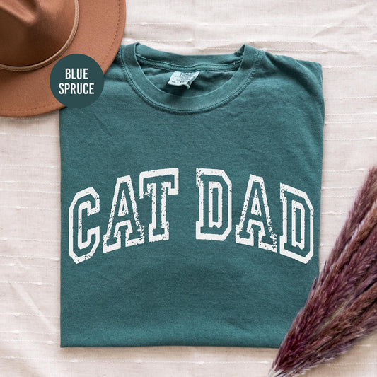 a green shirt with the word cat dad on it