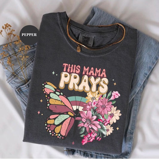 a t - shirt that says, this mama prays on it