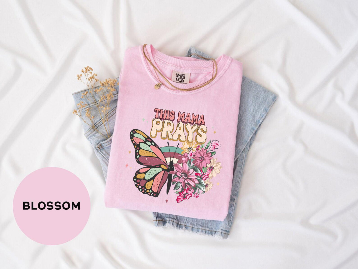 a pink shirt with a butterfly and flowers on it