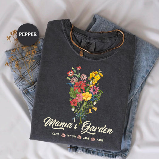 a t - shirt with flowers on it sitting on top of a pair of jeans