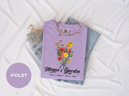 a purple shirt with flowers on it sitting on top of a bed
