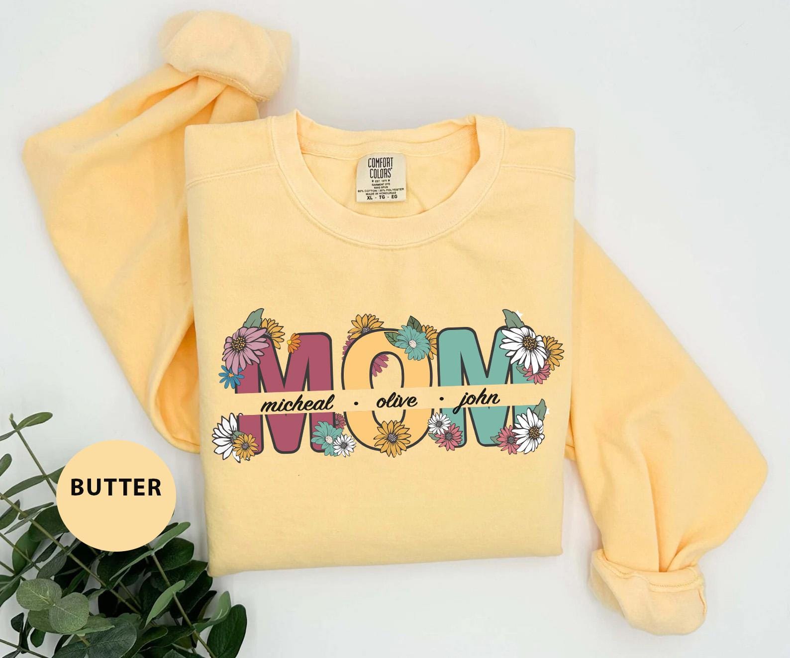 a yellow sweatshirt with the word mom printed on it