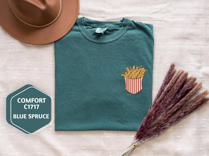 a t - shirt with french fries and a straw hat next to it