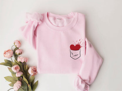 a pink sweater with a red heart on it